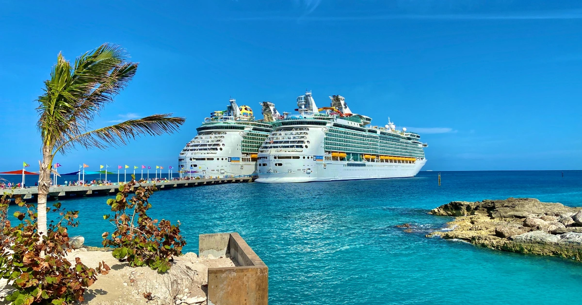 Cruise ships docked at tropical Caribbean port with turquoise waters and palm trees